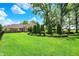 Spacious backyard with a well-maintained lawn, mature trees, and manicured garden beds, great for outdoor activities at 8905 Stonebriar Dr, Indianapolis, IN 46259