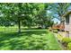 Picturesque backyard featuring mature trees, an outdoor deck, and manicured landscaping, perfect for entertaining at 8905 Stonebriar Dr, Indianapolis, IN 46259