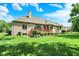 Expansive backyard featuring a well-maintained lawn, brick home, and a wooden deck, ideal for outdoor enjoyment at 8905 Stonebriar Dr, Indianapolis, IN 46259