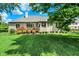Lush backyard with green lawn, mature trees, and a brick home with a wooden deck creating a serene outdoor space at 8905 Stonebriar Dr, Indianapolis, IN 46259