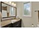 Charming bathroom showcasing a granite vanity, a decorative mirror, and a window at 8905 Stonebriar Dr, Indianapolis, IN 46259