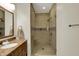 Bathroom featuring a wood vanity with a stone countertop and a tiled glass-enclosed shower at 8905 Stonebriar Dr, Indianapolis, IN 46259