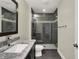 Modern bathroom with a tiled shower, black vanity, and a sleek design at 8905 Stonebriar Dr, Indianapolis, IN 46259
