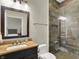 Modern bathroom featuring glass shower with tile walls, black vanity, and neutral walls at 8905 Stonebriar Dr, Indianapolis, IN 46259