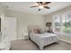 Cozy bedroom featuring a ceiling fan, neutral walls, plush carpet and a window with shutters at 8905 Stonebriar Dr, Indianapolis, IN 46259