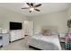 Bright bedroom with a ceiling fan, large dresser, a television, and neutral walls at 8905 Stonebriar Dr, Indianapolis, IN 46259