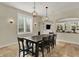 Window-lit dining room with tile floors, globe pendants and dark table set near built-in entertainment center at 8905 Stonebriar Dr, Indianapolis, IN 46259