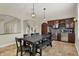 Spacious dining area features tiled flooring, wooden dining set, wine bar, and nearby staircase at 8905 Stonebriar Dr, Indianapolis, IN 46259