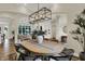 Bright dining room featuring hardwood floors, a modern chandelier, and views into the living room at 8905 Stonebriar Dr, Indianapolis, IN 46259