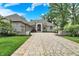 Beautiful brick home showcasing a well-manicured lawn and a paved circular driveway at 8905 Stonebriar Dr, Indianapolis, IN 46259