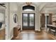 Welcoming foyer featuring hardwood floors, elegant lighting, and stylish decor leading into the dining area at 8905 Stonebriar Dr, Indianapolis, IN 46259