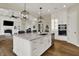 Open-concept kitchen featuring a large island, stainless steel appliances, and modern lighting fixtures at 8905 Stonebriar Dr, Indianapolis, IN 46259