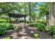 Beautiful backyard with stone pathway, large pergola, outdoor fireplace, and grill area surrounded by lush greenery at 8905 Stonebriar Dr, Indianapolis, IN 46259
