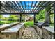 Covered outdoor kitchen with stainless steel appliances, stone countertops, and a view of the home's backyard at 8905 Stonebriar Dr, Indianapolis, IN 46259