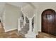 Staircase with carpet runner, decorative wrought iron railings and a wooden arched front door at 8905 Stonebriar Dr, Indianapolis, IN 46259