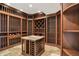 Lavish wine cellar displaying extensive bottle storage and a central marble-topped tasting table at 8905 Stonebriar Dr, Indianapolis, IN 46259