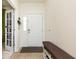 Bright foyer featuring a white door with sidelight, a brown accent bench and tiled floors at 928 Cherry Tree Ln, Greenwood, IN 46143