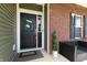 Inviting front entrance featuring a black door, decorative wreath, and potted plants, creating a warm, welcoming atmosphere at 928 Cherry Tree Ln, Greenwood, IN 46143