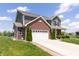 Two-story home featuring green siding, brick accents, an attached two car garage and a well-manicured front yard at 928 Cherry Tree Ln, Greenwood, IN 46143