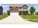 Two-story home featuring green siding, brick accents, an attached two car garage and a well-manicured front yard at 928 Cherry Tree Ln, Greenwood, IN 46143