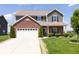 Two-story home featuring green siding, brick accents, an attached two car garage and a well-manicured front yard at 928 Cherry Tree Ln, Greenwood, IN 46143