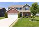Two-story home featuring green siding, brick accents, an attached two car garage and a well-manicured front yard at 928 Cherry Tree Ln, Greenwood, IN 46143