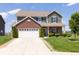 Two-story home featuring green siding, brick accents, an attached two car garage and a well-manicured front yard at 928 Cherry Tree Ln, Greenwood, IN 46143