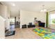 Inviting living area with neutral tones, leading to the playroom with bright playmat and toys at 928 Cherry Tree Ln, Greenwood, IN 46143