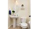 Cozy powder room featuring modern fixtures including a pedestal sink and toilet at 928 Cherry Tree Ln, Greenwood, IN 46143