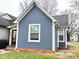 Picture showcasing the side of a single-Gathering home, with well-maintained lawn and light blue siding at 929 W Roache St, Indianapolis, IN 46208