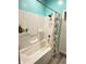 A shower enclosure with a grey and white shower curtain and wall mounted shelving at 929 W Roache St, Indianapolis, IN 46208