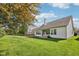 Expansive backyard featuring lush green lawn, mature trees, and a charming patio area with large windows at 9760 Innisbrook Blvd, Carmel, IN 46032