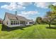 Lush backyard featuring a well-maintained lawn and mature trees, with a view of the home's exterior at 9760 Innisbrook Blvd, Carmel, IN 46032