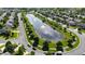 An aerial view shows the community's pond, winding roads, and homes nestled among lush trees at 10773 Brighton Knoll S Pkwy, Noblesville, IN 46060