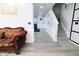 Inviting hallway featuring updated flooring, staircase, and a comfortable sitting area at 10773 Brighton Knoll S Pkwy, Noblesville, IN 46060