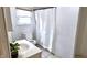 Compact bathroom with white fixtures, including a toilet, sink, and shower with a white curtain at 1148 N Pershing Ave, Indianapolis, IN 46222