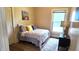 Bedroom featuring a large window, light walls, hardwood flooring, and a patterned comforter at 1148 N Pershing Ave, Indianapolis, IN 46222