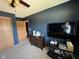 Bedroom featuring wood dresser, TV, dark blue accent wall, and neutral carpet at 1214 Lindsey Ln, Lebanon, IN 46052
