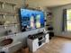 Bright living room with large TV and decorative shelves for storage and display at 1214 Lindsey Ln, Lebanon, IN 46052