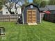 Backyard shed with wooden doors and wood pile offers storage and rustic charm at 1214 Lindsey Ln, Lebanon, IN 46052