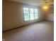 Comfortable carpeted bedroom featuring a ceiling fan and a sunny window overlooking the green outdoors at 123 Old Farm Rd, Danville, IN 46122