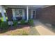 Inviting porch with seating area, lush landscaping, and charming brick facade at 123 Old Farm Rd, Danville, IN 46122