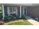 Inviting front porch with seating, lush landscaping, and a charming brick facade at 123 Old Farm Rd, Danville, IN 46122
