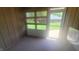 Bright sunroom featuring wood paneling and large windows with views of the backyard at 123 Old Farm Rd, Danville, IN 46122