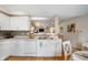 Well-lit kitchen with white cabinets, modern countertops, and a view of the living area at 12446 Deerview Dr, Noblesville, IN 46060