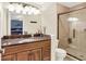 Bathroom with a brown granite counter, and a glass enclosed shower with beige tile at 12681 E 79Th St, Indianapolis, IN 46236
