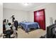 Simple bedroom featuring neutral carpet and a bed with blue coverlet and red window coverings at 12681 E 79Th St, Indianapolis, IN 46236