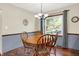 Bright dining area with a wooden table, comfortable chairs, and a large window overlooking the backyard at 12681 E 79Th St, Indianapolis, IN 46236
