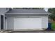 Attached two-car garage with a white door and gray siding for convenient parking and storage at 12681 E 79Th St, Indianapolis, IN 46236