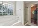 Well-lit bathroom with tiled bathtub and shower combo and walk-in closet at 13063 E 131St St, Fishers, IN 46037